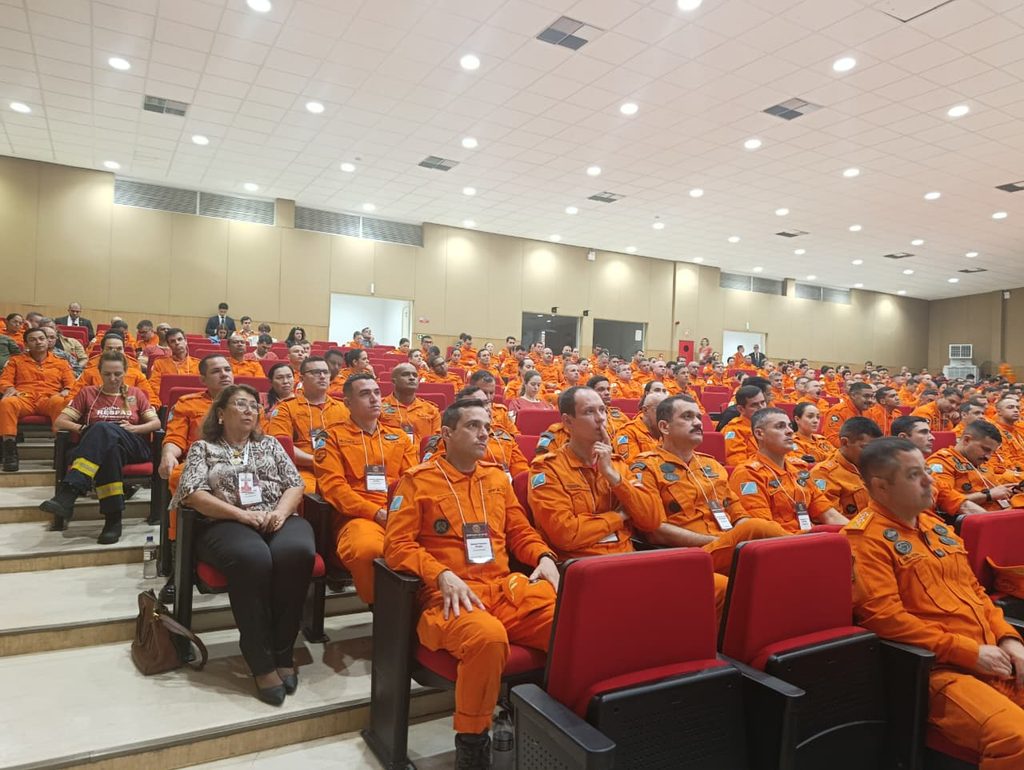 bombeiros sentados na plateria durante evento em auditório