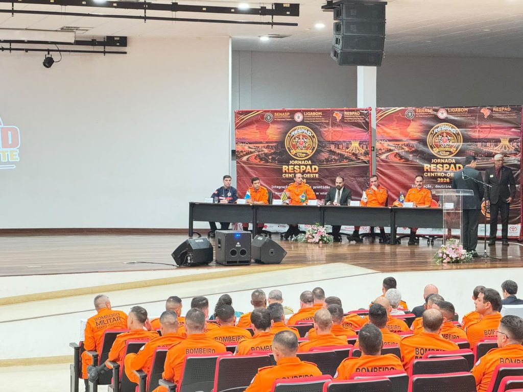 bombeiros sentados a mesa durante evento em auditório